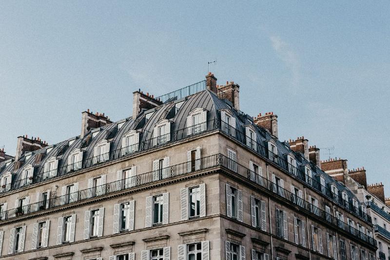 Façade parisienne haussmannienne en pierre de taille, emblème de l'architecture ancienne française, reflétant l'élégance et la tradition urbaine