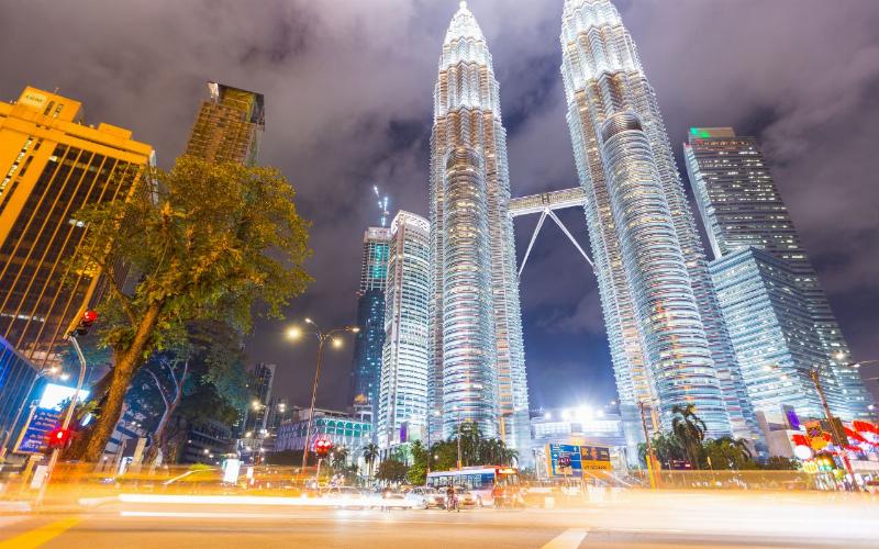 Les Tours Petronas, symboles de l'architecture moderne de Kuala Lumpur, dominant le paysage urbain malaisien sous un ciel bleu