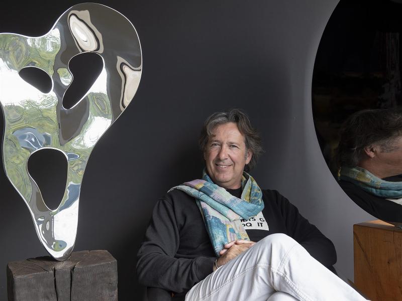 Un artiste français travaillant sur une sculpture murale métal contemporaine dans son atelier