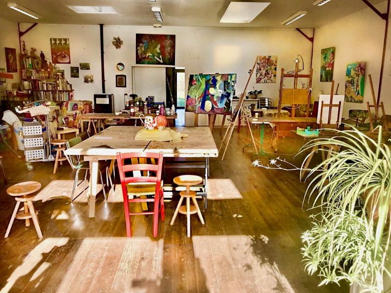 Artiste française peignant un tableau acrylique sur toile dans un atelier lumineux