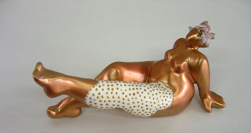 Une sculptrice française travaillant sur une sculpture de femme aux formes généreuses dans son atelier d'art.