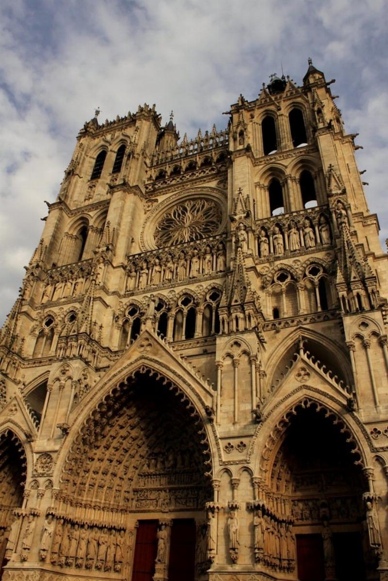 Façade d'une cathédrale gothique française, avec ses sculptures complexes et ses rosaces