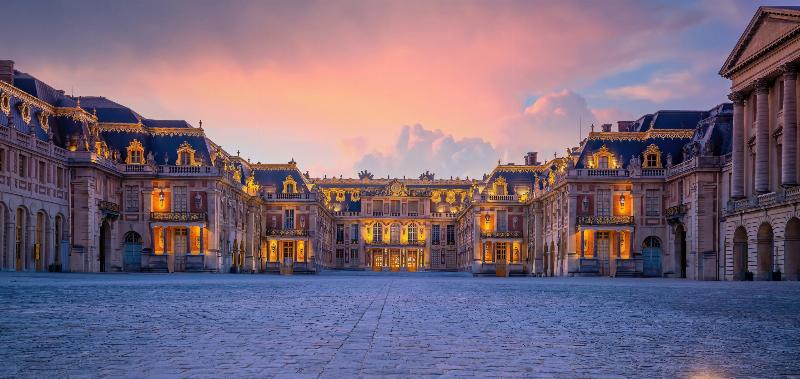 La majestueuse Galerie des Glaces au Château de Versailles, illuminée par la lumière naturelle, avec ses miroirs reflétant les nombreuses pièces et l'opulence royale française