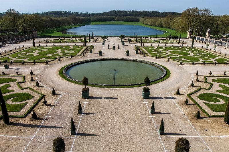 Une vue panoramique des jardins de Le Nôtre à Versailles avec des perspectives symétriques et des fontaines