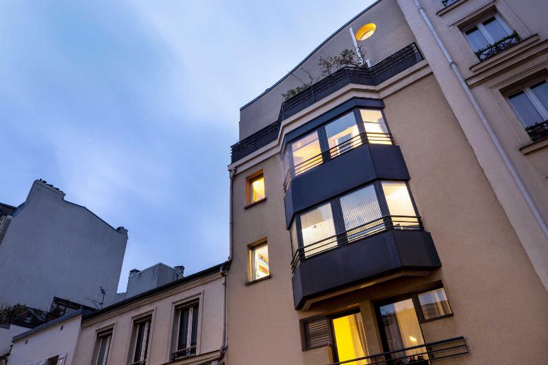 Intérieur élégant d'une galerie d'art parisienne avec des peintures lumineuses.