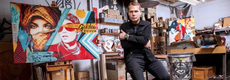 Un artiste urbain français travaillant sur une grande fresque de graffiti peinture, utilisant des bombes aérosols