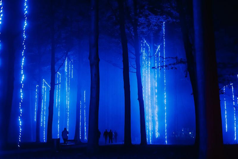 Une grande sculpture design illuminée la nuit dans un parc parisien, créant une ambiance magique et contemplative