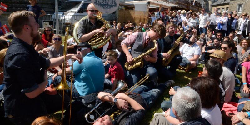 Vue dynamique d'un groupe de musique gothique français en plein concert, avec le chanteur en pleine performance énergique sur scène