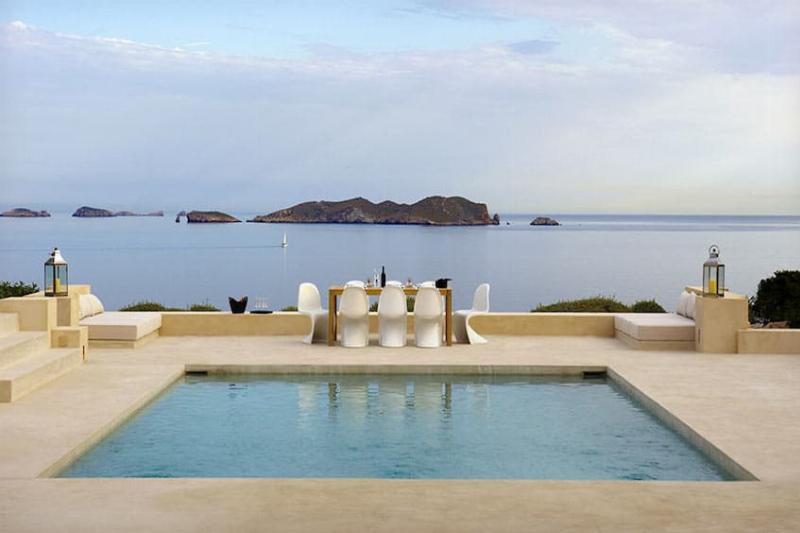 Intérieur minimaliste d'une villa cycladique moderne avec meubles épurés et vue sur la mer