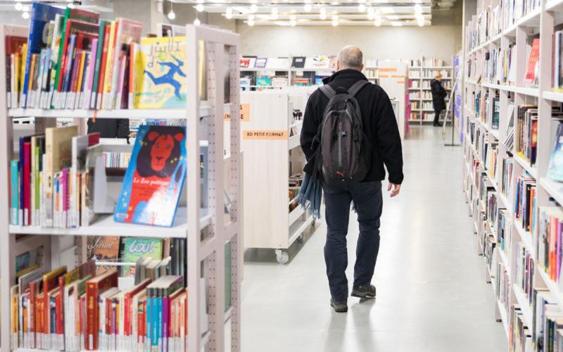 Une femme lisant un livre de littérature espagnole moderne sur un banc parisien