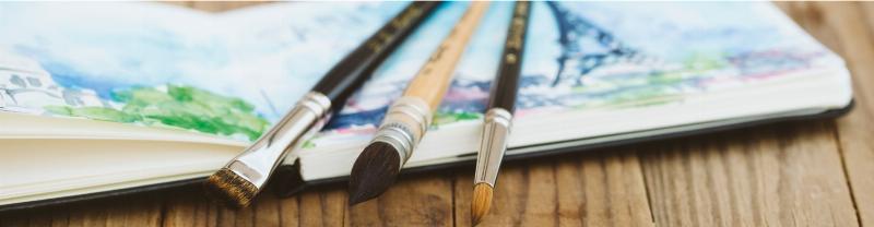 Un assortiment de matériel de peinture de qualité française, essentiel pour créer une peinture sur toile abstraite, incluant des toiles, des pinceaux et des tubes de couleur vive.