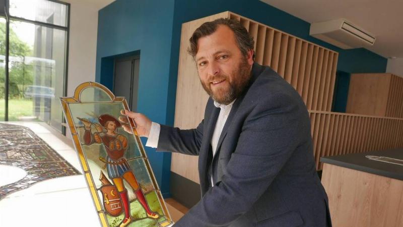 Maître verrier français restaurant un vitrail de Notre-Dame dans son atelier