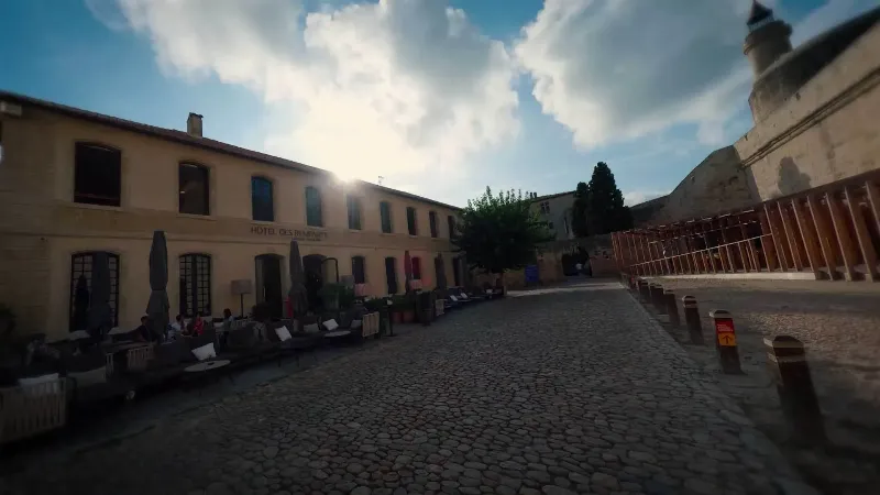 Un groupe de personnes admirant la façade majestueuse d'un bâtiment classique français baigné par le soleil