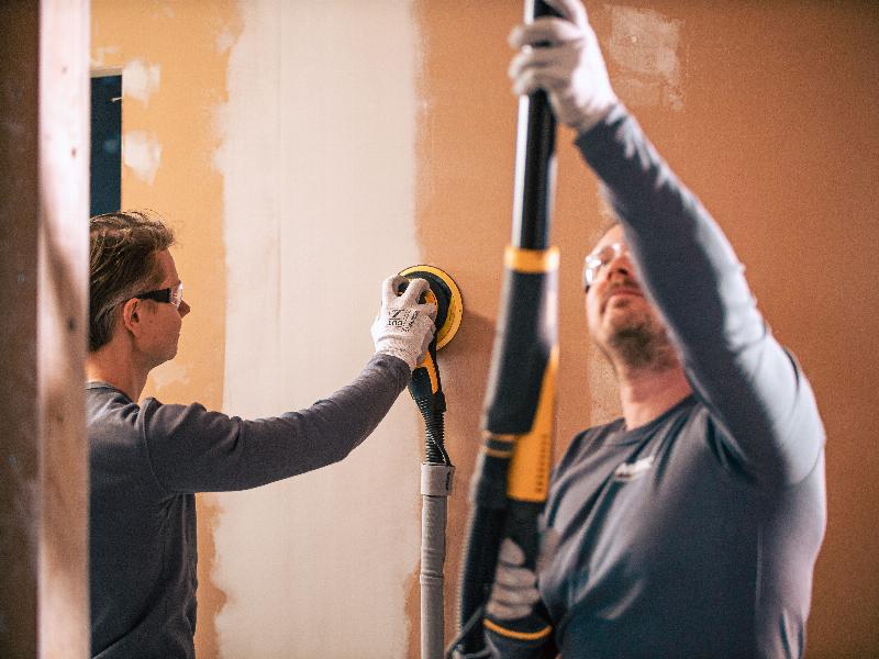 Ponceuse électrique ponçant un mur peint pour une préparation parfaite