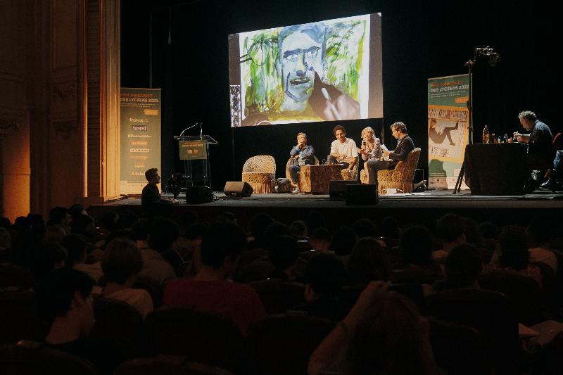 Un lecteur passionné plongé dans un des livres sélectionnés pour le Prix Goncourt 2022, dans un café littéraire parisien