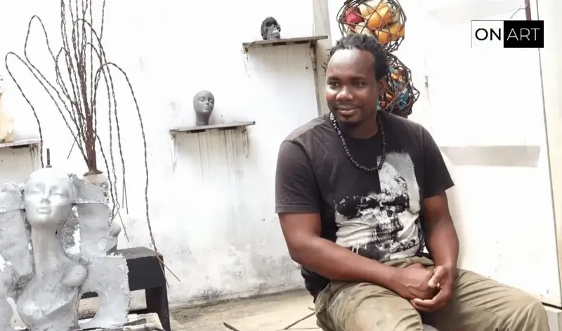 Artiste travaillant une sculpture métal contemporaine dans son atelier