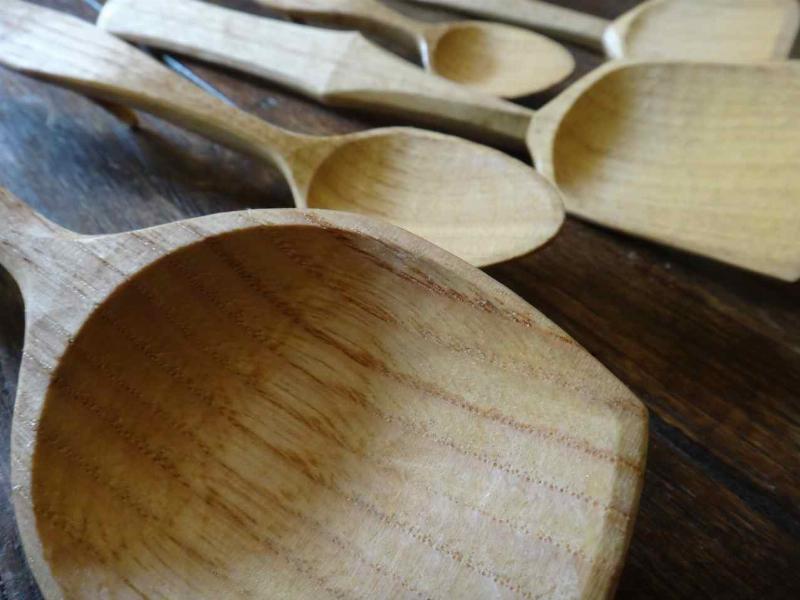 Un sculpteur concentré travaillant le bois avec un ciseau et un maillet dans son atelier artisanal.