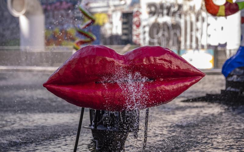 Une statue éléphant de grande taille, conçue à partir de matériaux recyclés et colorés, exposée dans un espace urbain moderne.