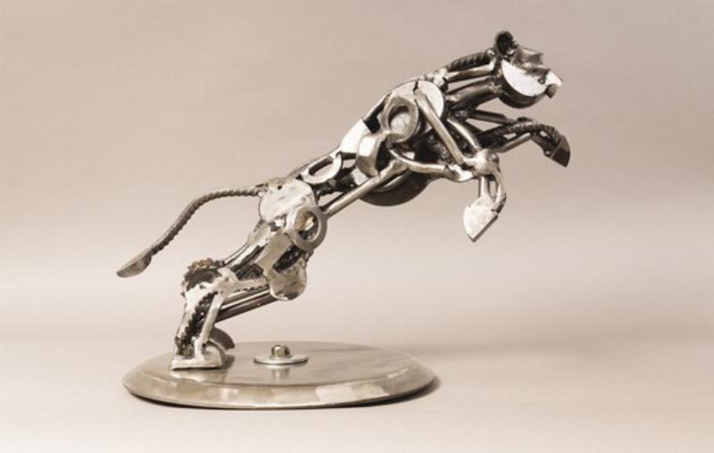 Une sculpture taureau contemporaine en acier poli, aux lignes épurées et design, exposée dans une galerie d'art minimaliste.