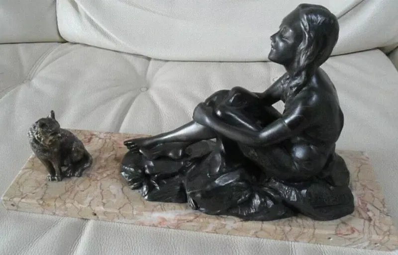 Une statue malgache imposante, représentant une figure humaine stylisée, debout, avec des motifs géométriques complexes. La sculpture est en bois foncé, patiné par le temps, et dégage une forte présence spirituelle, incarnant l'art ancestral et la tradition malgache.