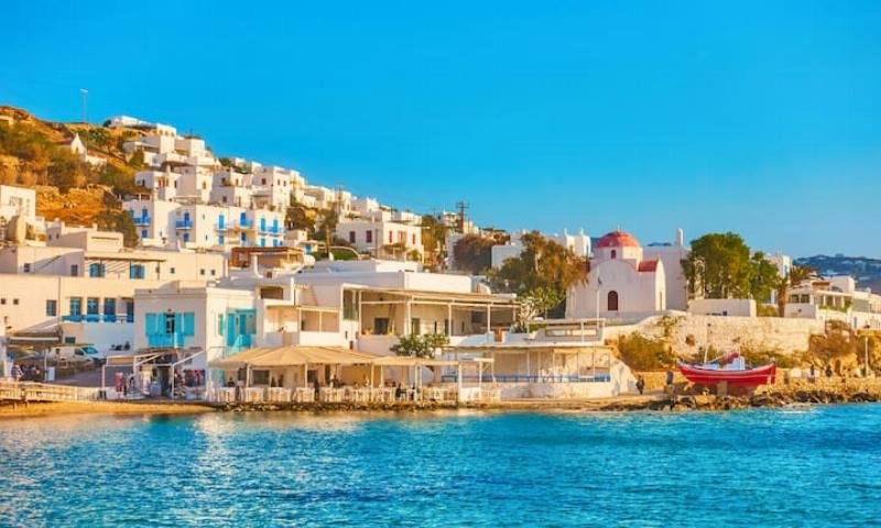 Vue aérienne d'une villa cycladique moderne avec piscine à débordement et mer Égée