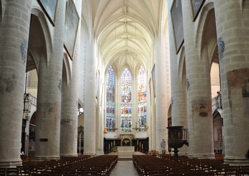 Vue de l'intérieur de Notre-Dame de Paris restaurée, montrant la nef et les arcs gothiques illuminés par les vitraux.