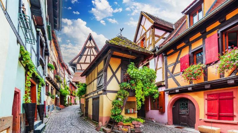 Une rue fleurie typique d'un village alsacien avec des maisons à colombages colorées