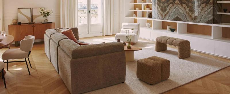 Un intérieur de maison moderne à la française, avec un grand salon lumineux, un mobilier contemporain confortable, des touches d'art et des matériaux naturels, créant une ambiance cosy et élégante.