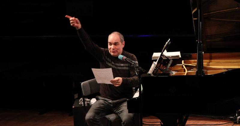 Un animateur radio musique classique dans son studio, micro devant, jouant des partitions