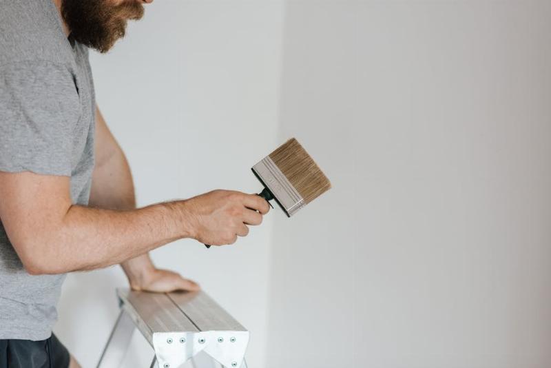 Artisan peintre appliquant une peinture murale à Agen avec un rouleau