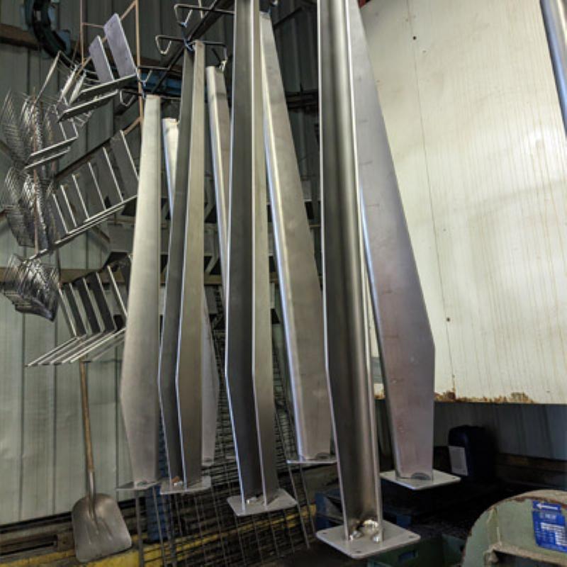 Application précise de peinture poudre époxy sur une pièce métallique, mettant en avant le pistolet électrostatique et la couche uniforme.