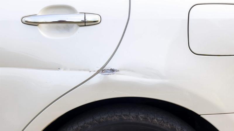 Application méticuleuse de la peinture de retouche sur une carrosserie de voiture