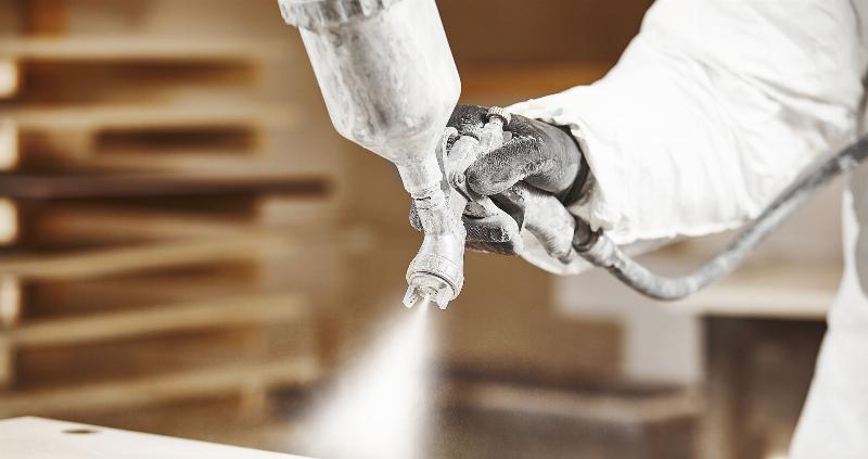 Application minutieuse de vernis pour peinture sur bois sur une table