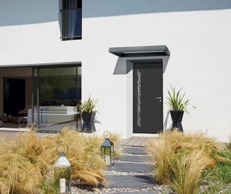 Architecture contemporaine avec une marquise en verre et métal, protégeant l'entrée