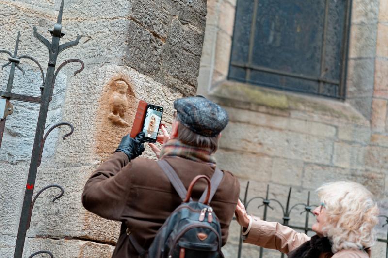 Détail d'une gargouille perchée sur un contrefort de Notre-Dame de Paris, regardant vers la ville. 
