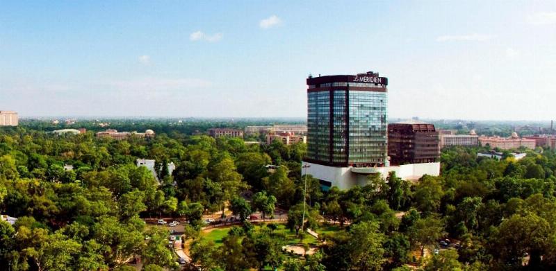 Des visiteurs explorant une cour intérieure d'un monument d'architecture indienne moderne, appréciant le design et l'atmosphère.