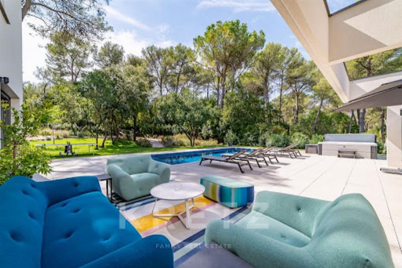 Vue aérienne d'une architecture maison moderne piscine parfaitement intégrée dans un paysage méditerranéen français, avec des matériaux naturels et un design épuré