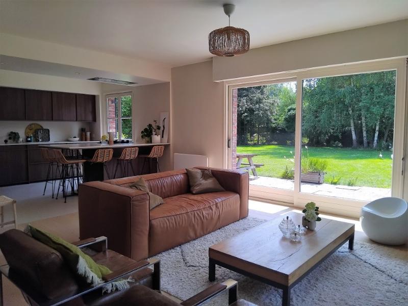 Une maison mid-century modern française avec de grandes baies vitrées et des lignes épurées