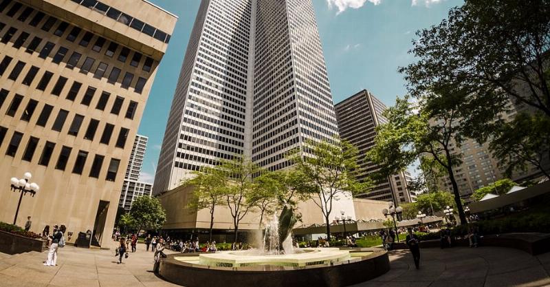 La skyline moderne de Montréal, avec la Place Ville-Marie et d'autres gratte-ciel emblématiques, sous un ciel bleu.