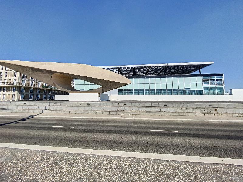 Structure architecturale moderne en béton et acier avec grandes baies vitrées