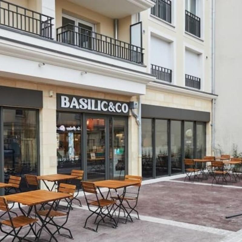 Intérieur lumineux d'un bâtiment moderne thaïlandais avec une grande baie vitrée et un patio verdoyant