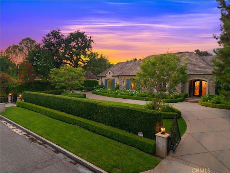 Vue intérieure d'une maison moderniste californienne avec de grandes baies vitrées et des structures en acier, mettant en valeur la fusion intérieur-extérieur.