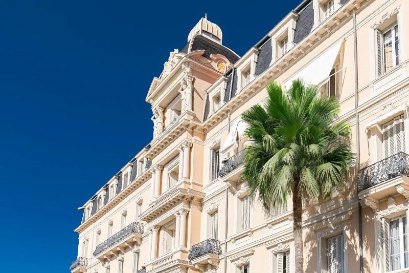 Façade d'un bâtiment néo-classique moderne à Paris, avec des colonnes stylisées et des lignes épurées