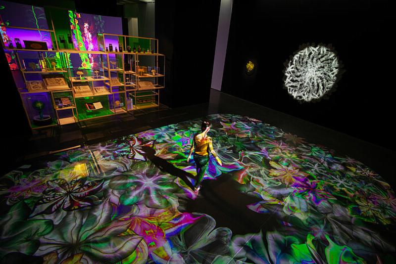 Des visiteurs interactifs avec une installation d'art contemporain lumineuse et colorée dans une galerie française