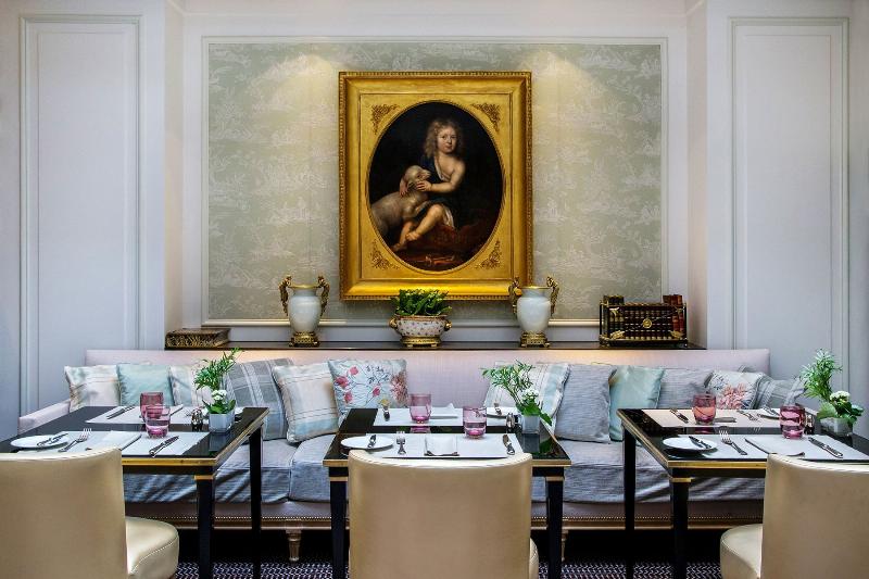 Une table de petit déjeuner élégante avec une tasse de café, une pâtisserie et un livre, dans un intérieur français raffiné