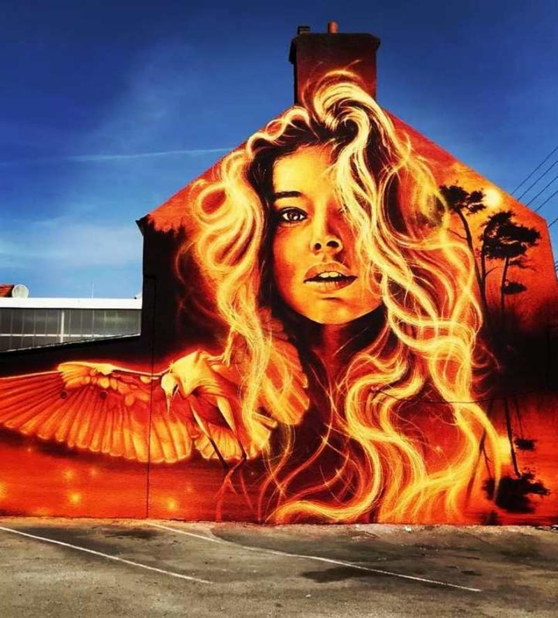 Mural de street art coloré et complexe sur un mur d'Hôtel de Ville, mêlant graffitis et figures stylisées