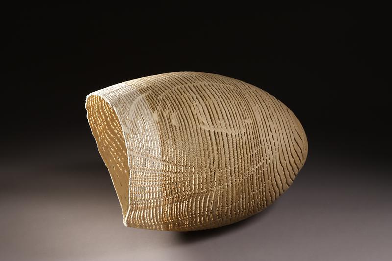 Artiste français dans son atelier, travaillant une sculpture de tronc d'arbre