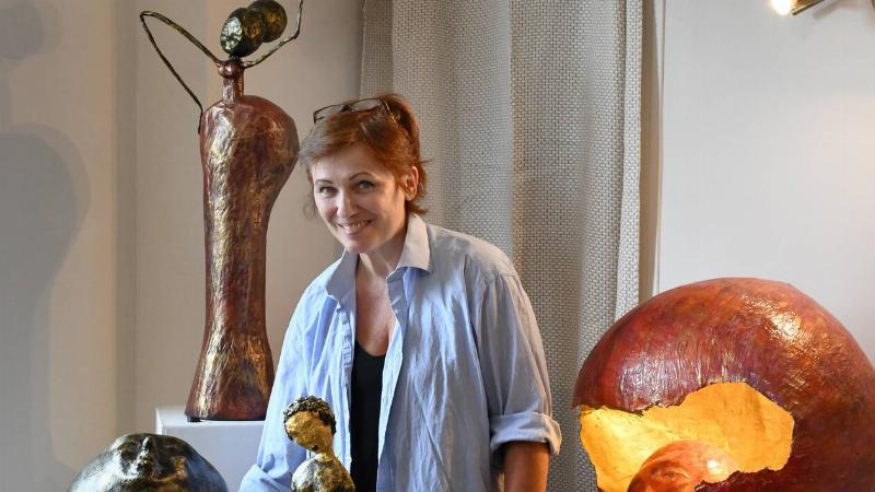 Artiste française travaillant sur une sculpture en papier mâché dans son atelier