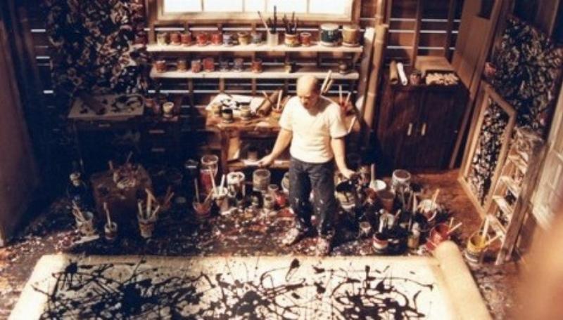 Artiste peignant avec un chevalet ergonomique en studio