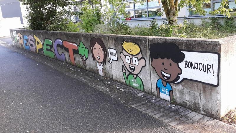 Élèves travaillant sur une fresque murale collective pour un projet communautaire à l'école